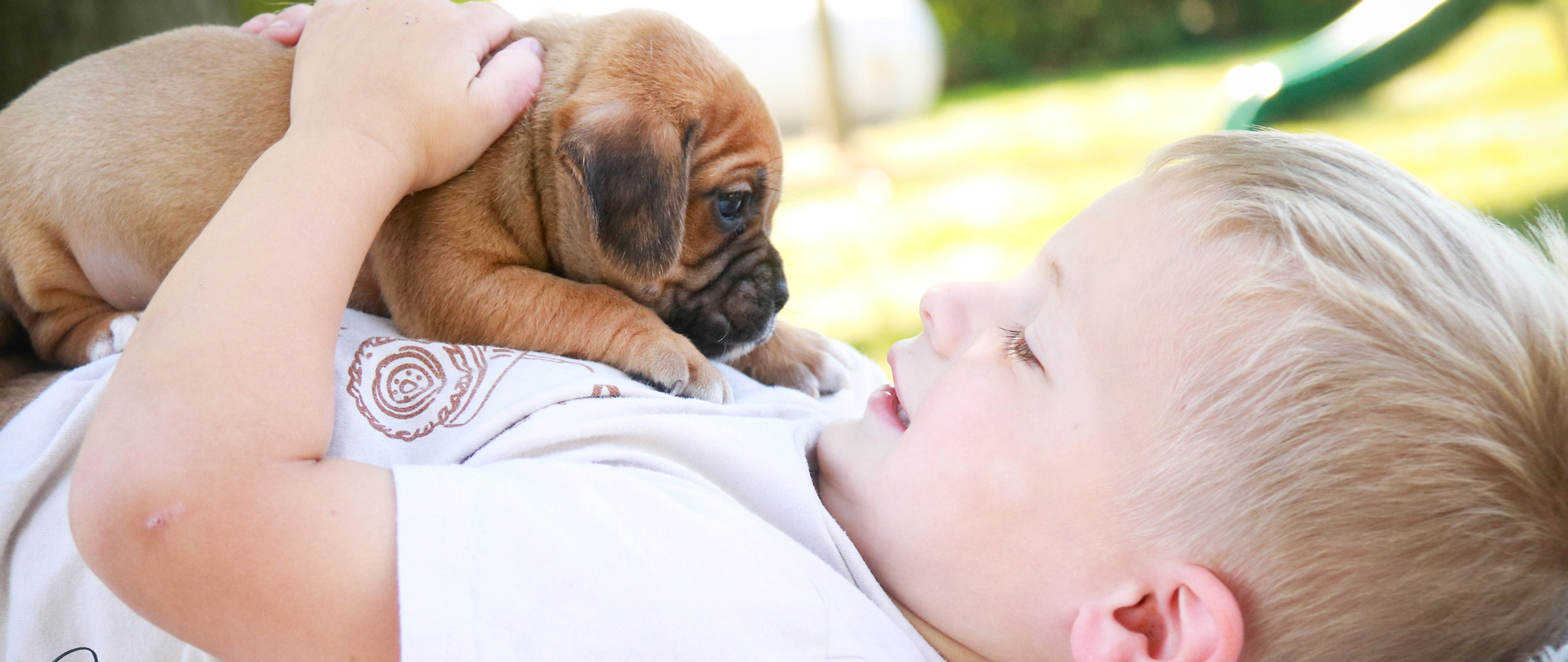 A baby resting beside a puppy